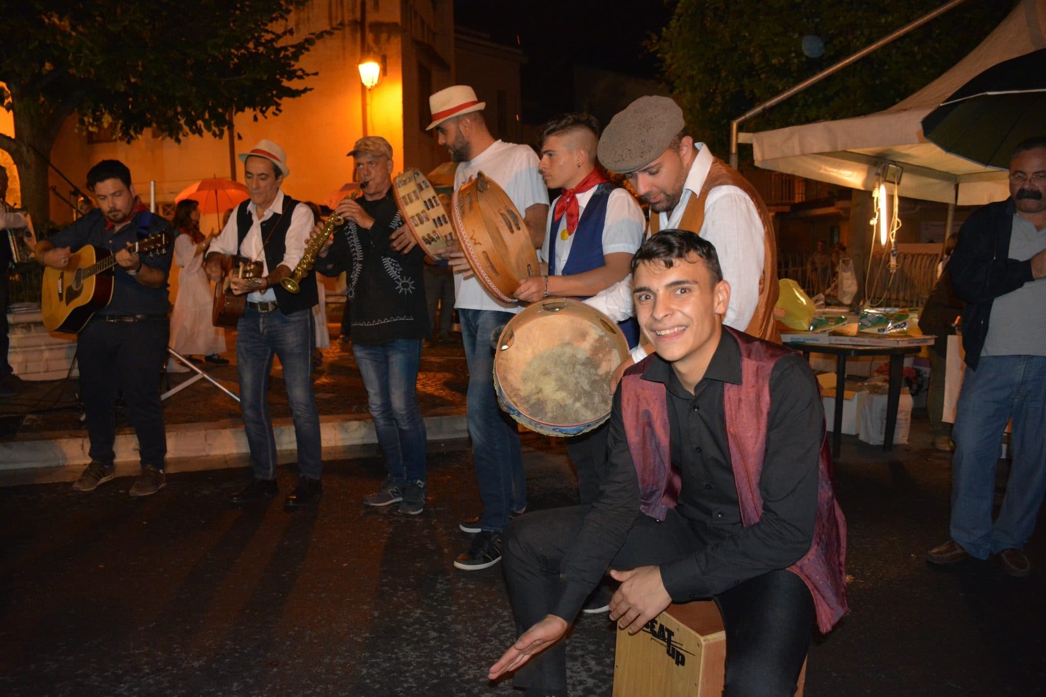 I musicisti popolari con i tamburelli che suonano tra le case del borgo