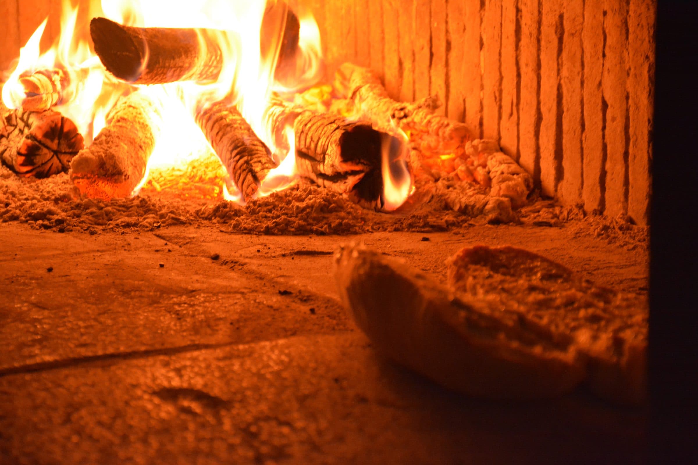 Il pane che cuoce dentro il forno a legna acceso, in un cortile del borgo