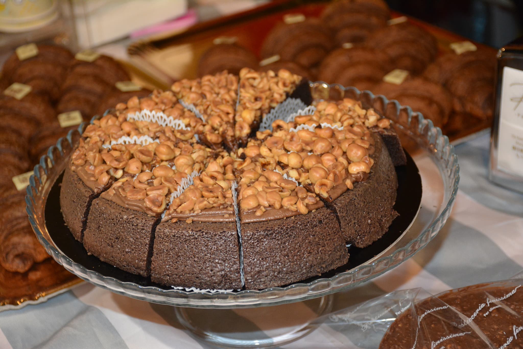 Una torta al cioccolato coperta di nocciole su un banco di pasticceria durante la sagra