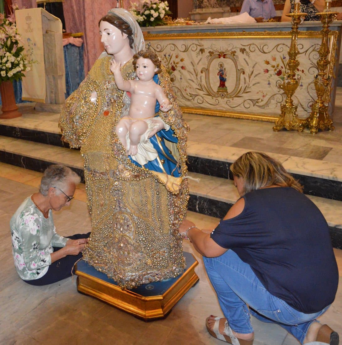 La Vestizione d’Oro: il manto di ex voto cucito sulla statua della Madonna, nel santuario